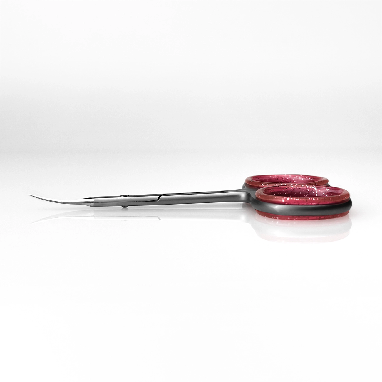 Side view of curved cuticle scissors with ergonomic finger grip
